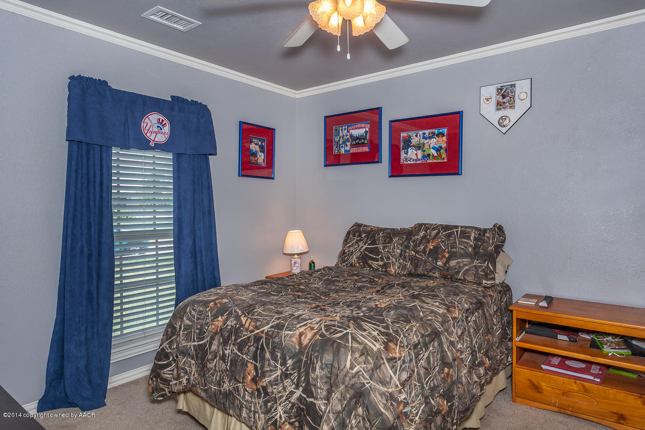 5811 South Rusk Street Amarillo, TX 79118 - Photo 15 of 22 a bedroom with a bed and a chandelier