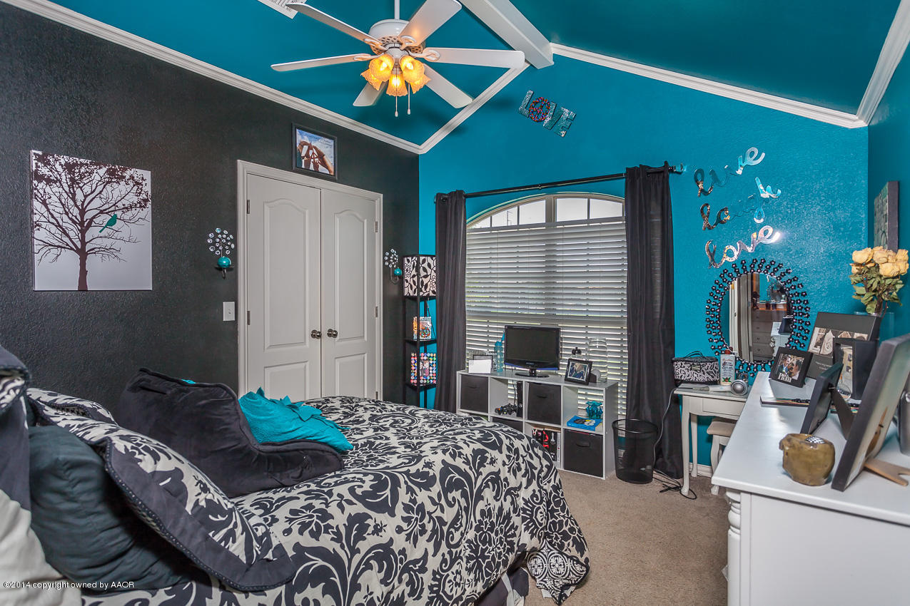 5811 South Rusk Street Amarillo, TX 79118 - Photo 17 of 22 a bedroom with a bed and a chandelier