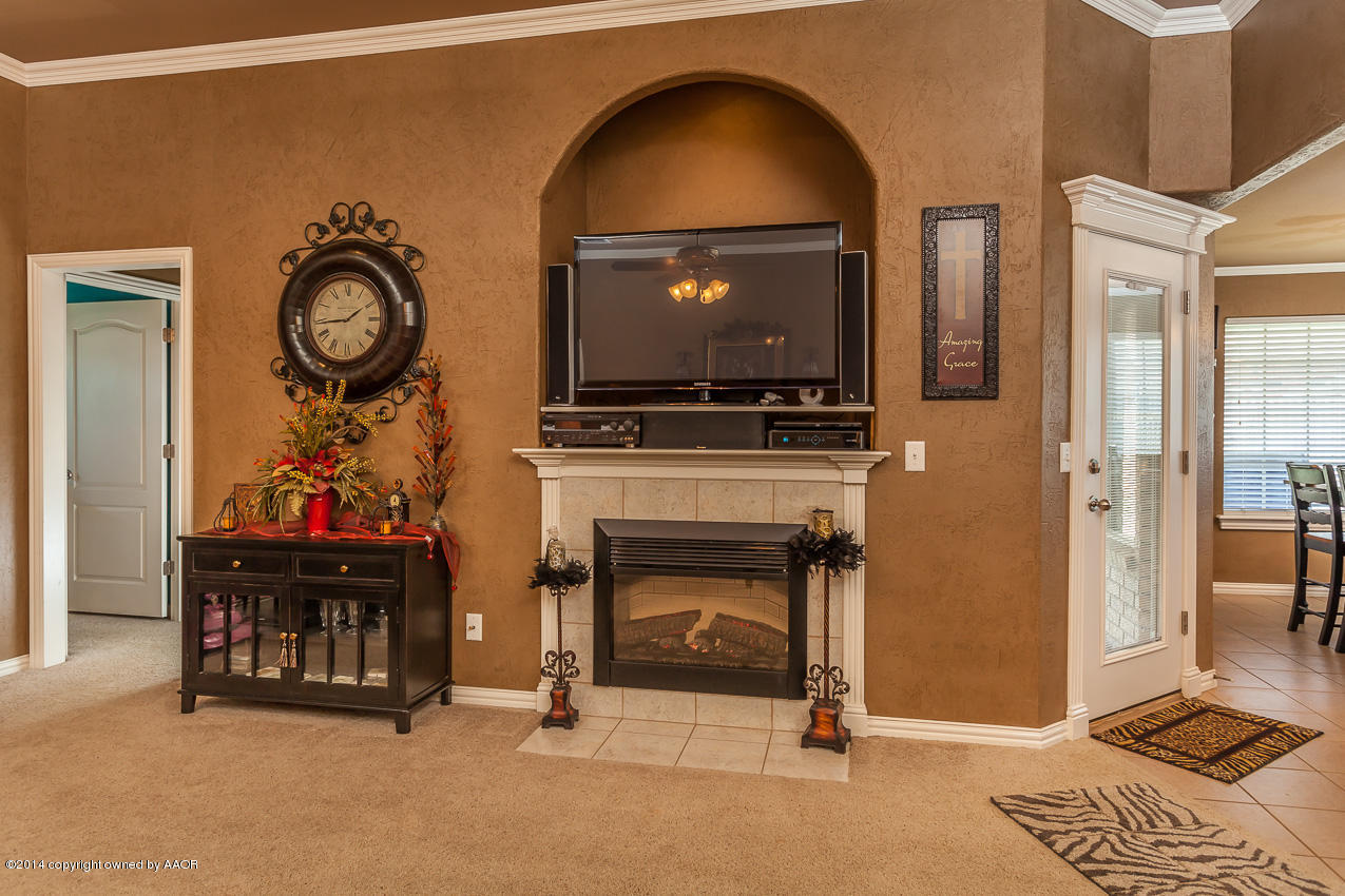 5811 South Rusk Street Amarillo, TX 79118 - Photo 3 of 22 a living room with furniture a flat screen tv and a fireplace