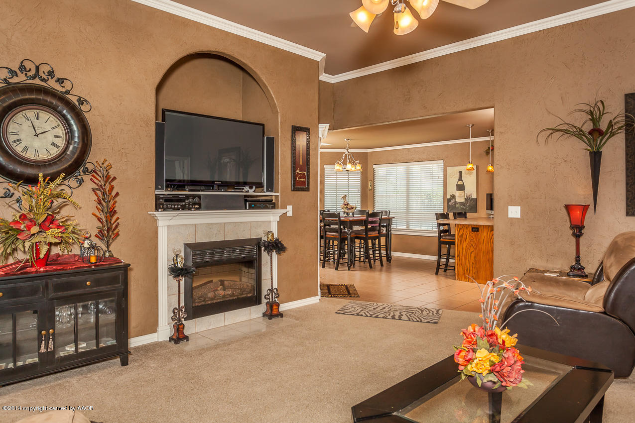 5811 South Rusk Street Amarillo, TX 79118 - Photo 5 of 22 a living room with furniture a flat screen tv and a fireplace