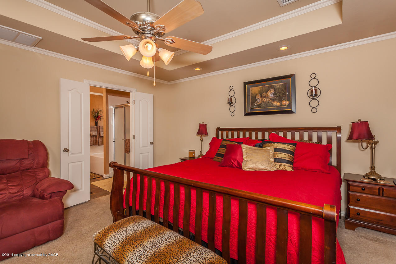 5811 South Rusk Street Amarillo, TX 79118 - Photo 10 of 22 a bedroom with a bed and a chandelier