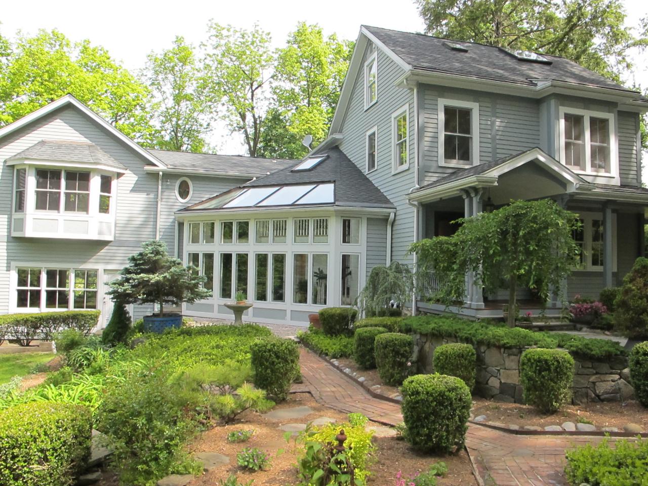 336 Ponus Ridge Road New Canaan, CT 06840 - Photo 21 of 28 a front view of a house with a yard and potted plants
