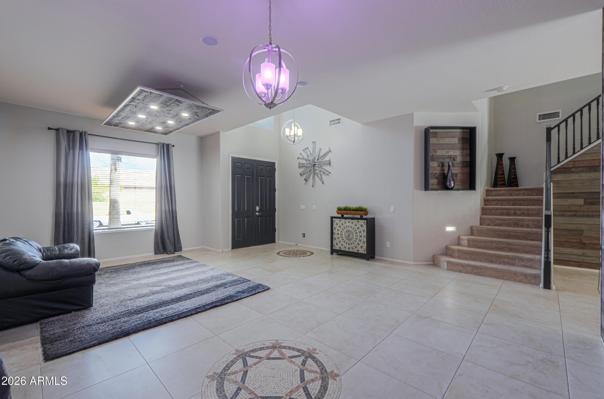 45247 West Jack Rabbit Trail Maricopa, AZ 85139 - Photo 12 of 75 a view of an empty room with wooden floor and a chandelier