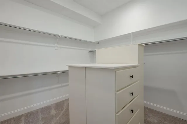 a view of an empty room with a fireplace and a window