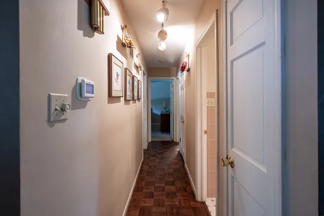 a view of a hallway with wooden floor and staircase