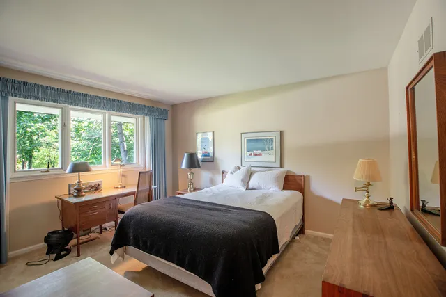 a bedroom with a bed and a large window