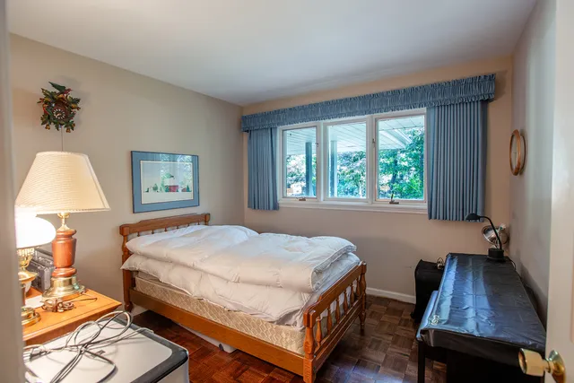 a bed sitting in a bedroom next to a window