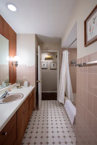 a bathroom with a double vanity sink a toilet a mirror and shower