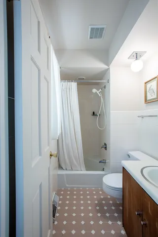 a bathroom with a granite countertop sink a toilet and shower