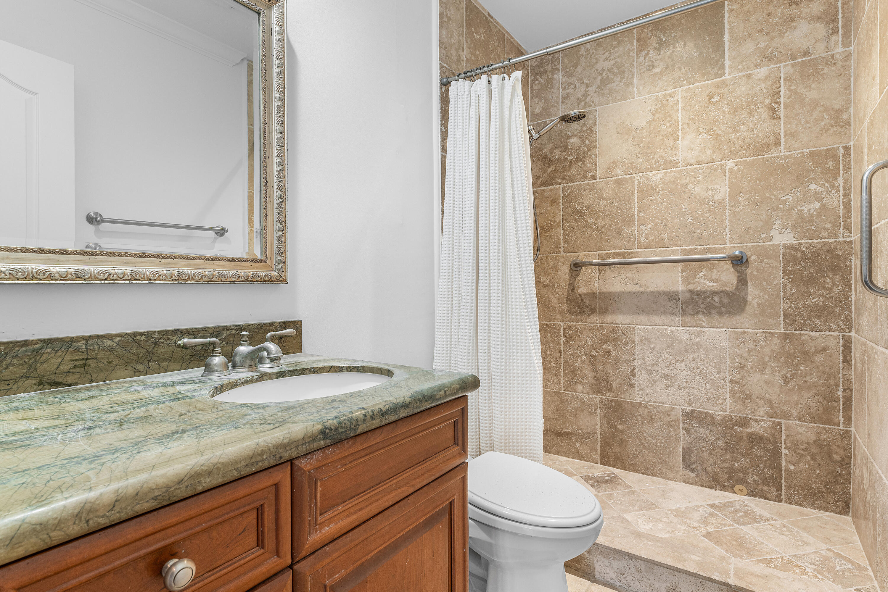 783 Valencia Drive Boca Raton, FL 33432 - Photo 32 of 45 a bathroom with a granite countertop sink a toilet a mirror and shower