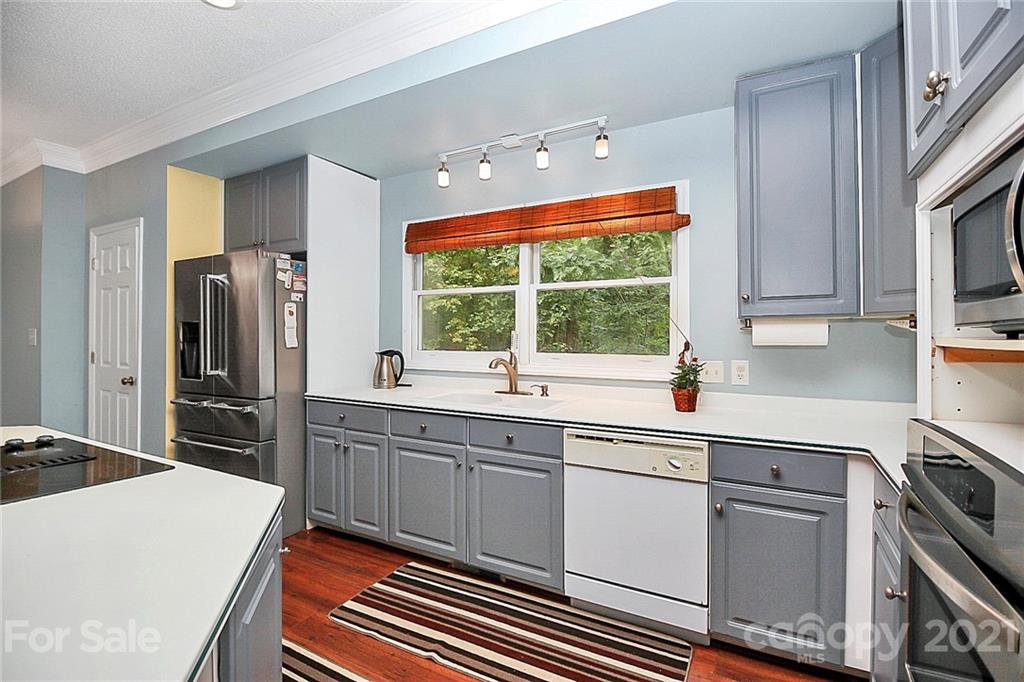 4900 Spring Lane Charlotte, NC 28213 - Photo 12 of 31 a kitchen with white cabinets and stainless steel appliances