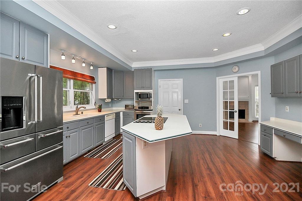 4900 Spring Lane Charlotte, NC 28213 - Photo 8 of 31 a kitchen with stainless steel appliances granite countertop a refrigerator a sink dishwasher a stove and white countertops with wooden floor