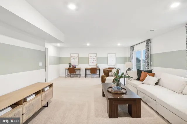 a living room with furniture and a refrigerator