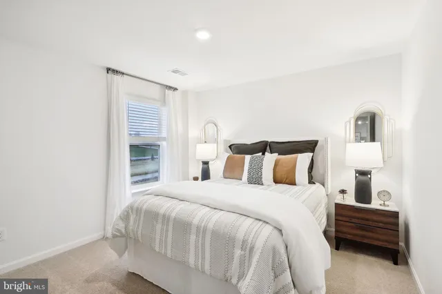 a bedroom with a bed and painting on the wall