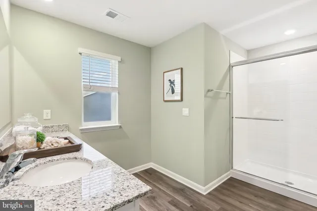 a bathroom with a granite countertop sink and a mirror