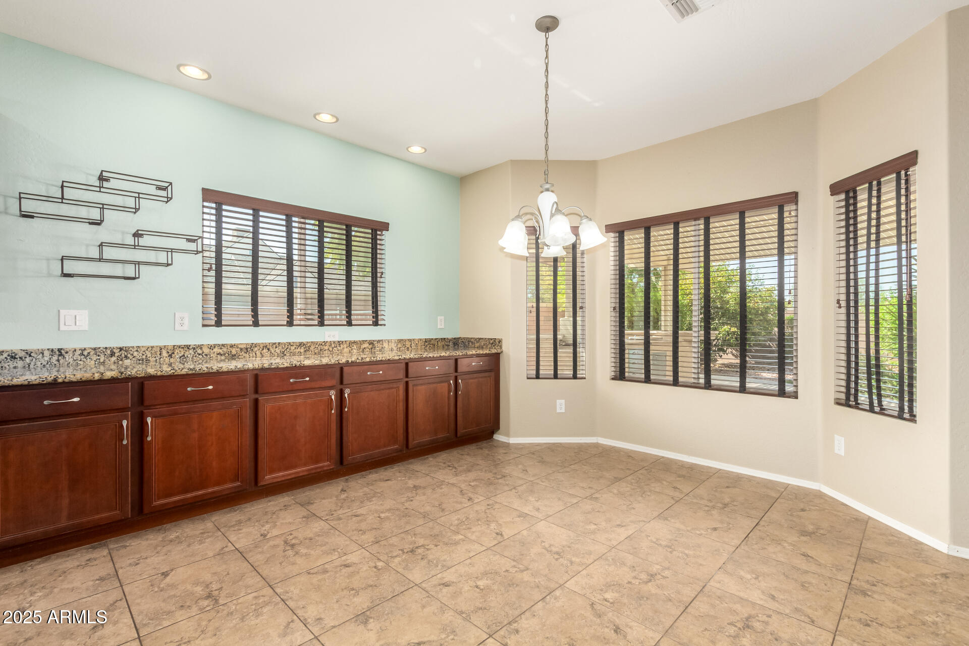 2806 East Trigger Way Gilbert, AZ 85297 - Photo 12 of 40 a large kitchen with kitchen island granite countertop a large window and cabinets