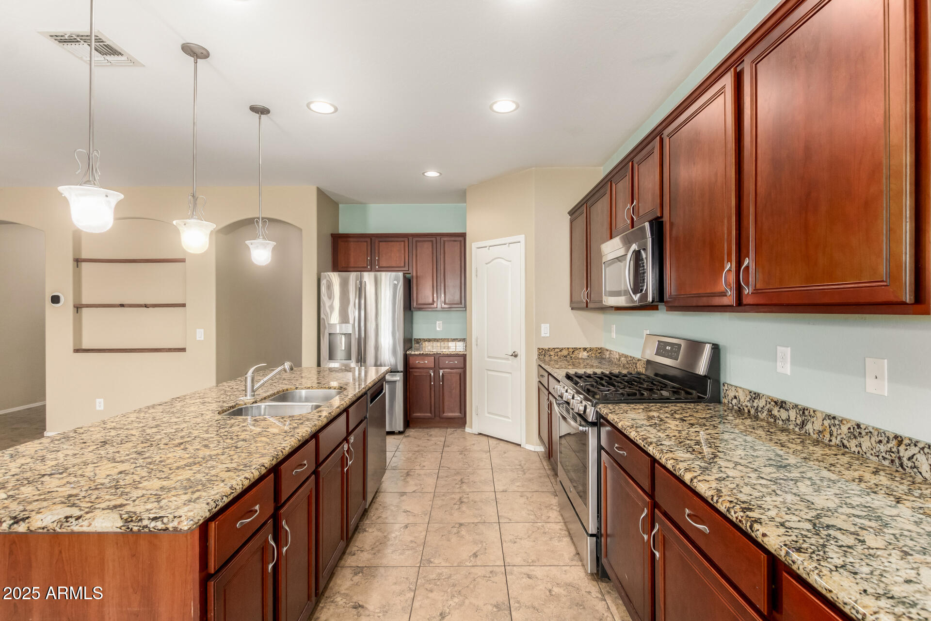 2806 East Trigger Way Gilbert, AZ 85297 - Photo 16 of 40 a kitchen with stainless steel appliances granite countertop a kitchen island a stove a refrigerator and a sink