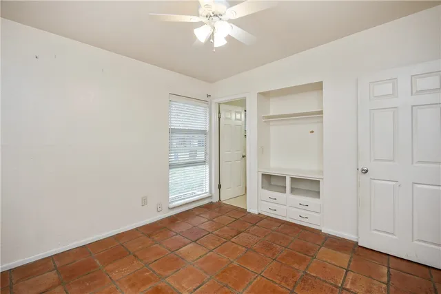 an empty room with a fireplace and windows