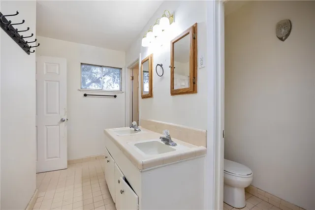 a bathroom with a sink mirror and toilet