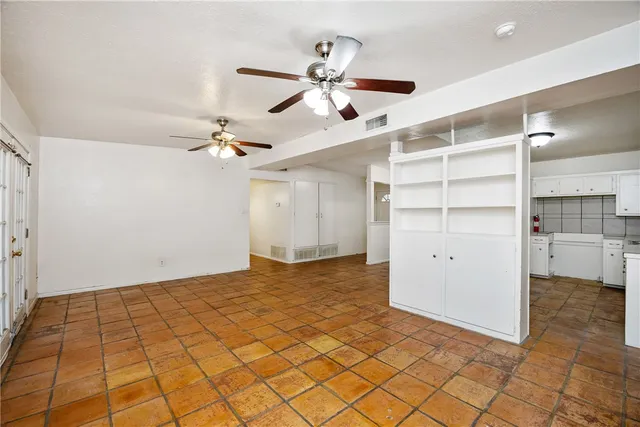 a view of a room with a ceiling fan and entryway