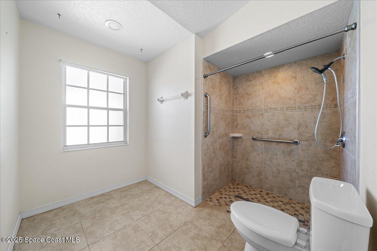 875 Evergreen Place Rockledge, FL 32955 - Photo 16 of 27 a bathroom with a granite countertop toilet a sink and shower
