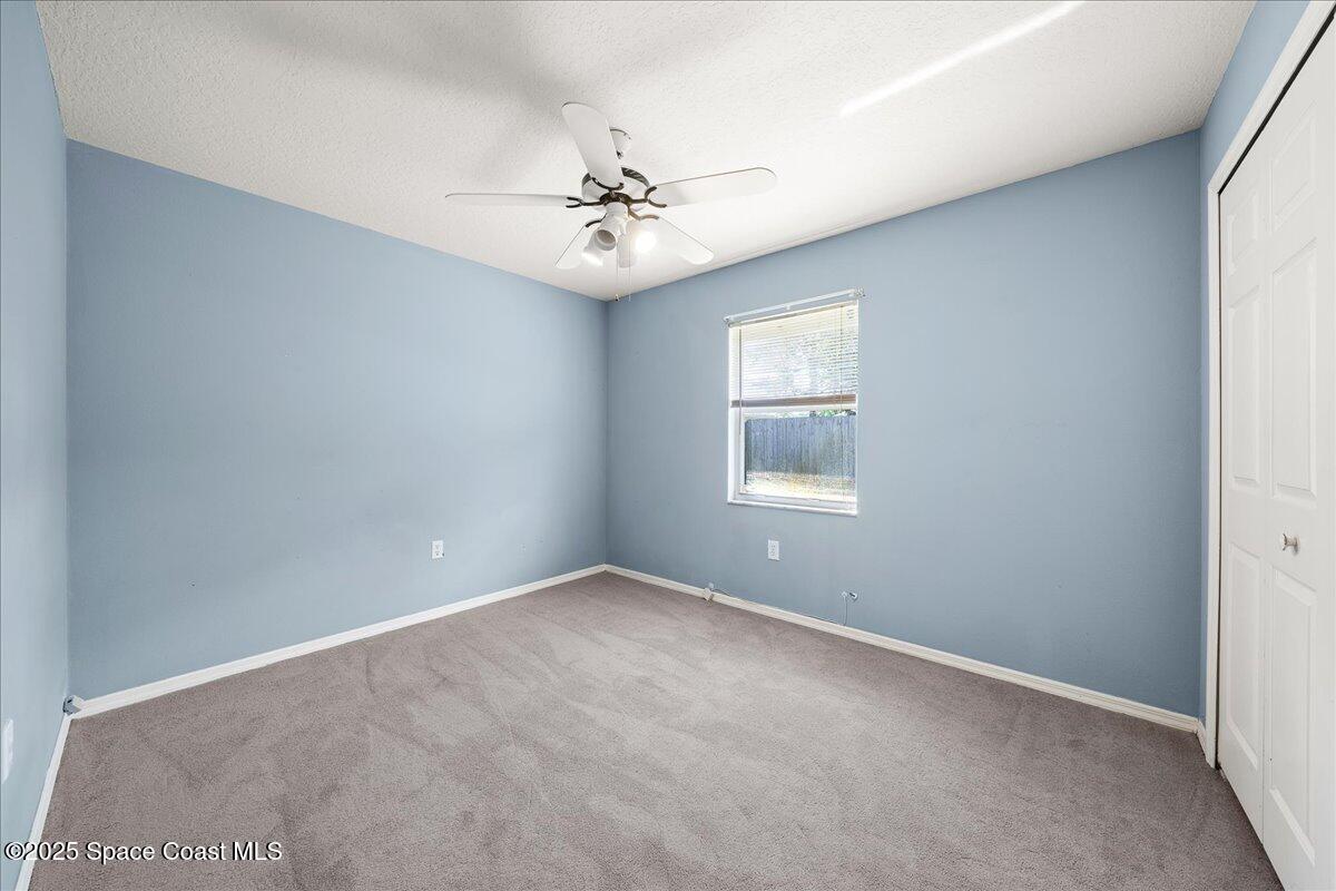 875 Evergreen Place Rockledge, FL 32955 - Photo 19 of 27 an empty room with windows and fan
