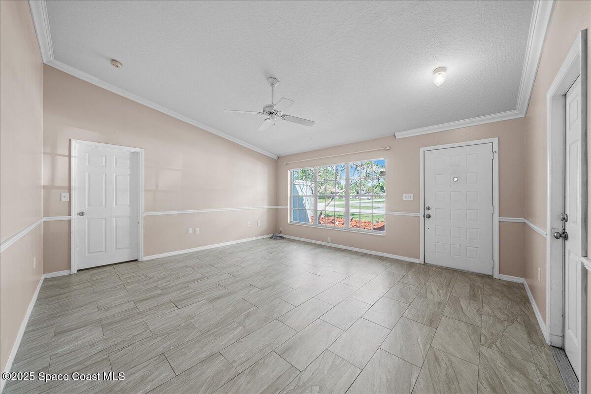875 Evergreen Place Rockledge, FL 32955 - Photo 4 of 27 an empty room with wooden floor and windows
