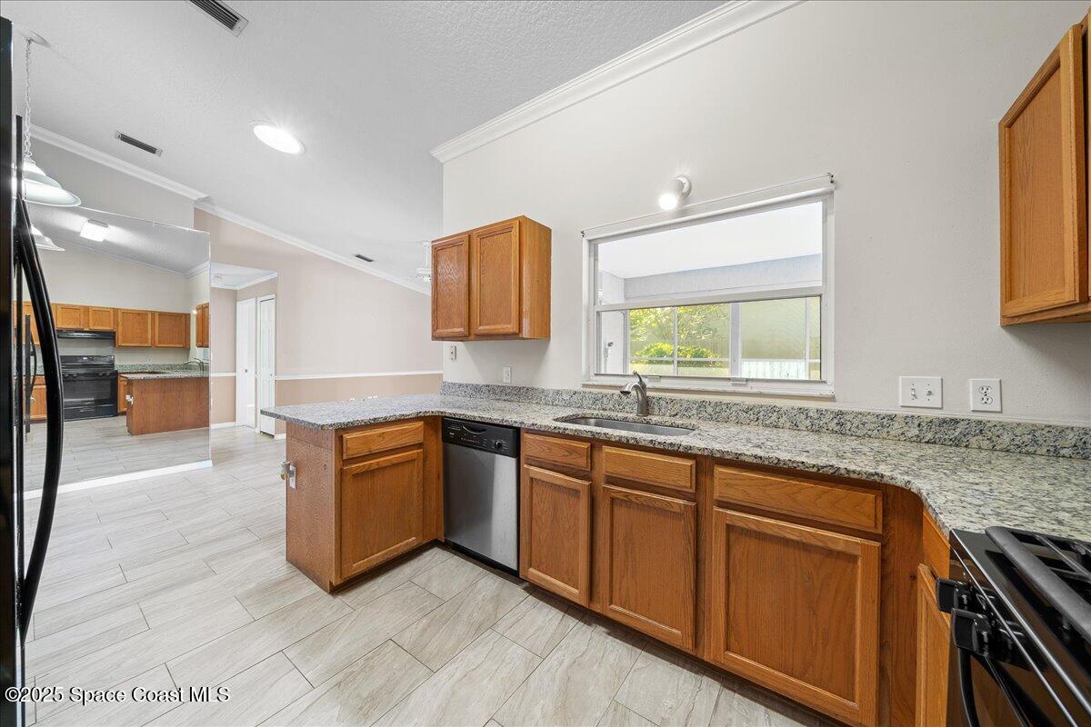 875 Evergreen Place Rockledge, FL 32955 - Photo 9 of 27 a kitchen with stainless steel appliances granite countertop a sink and dishwasher a stove top oven with wooden floor