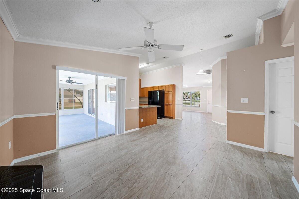 875 Evergreen Place Rockledge, FL 32955 - Photo 10 of 27 an empty room with wooden floor kitchen view and a window
