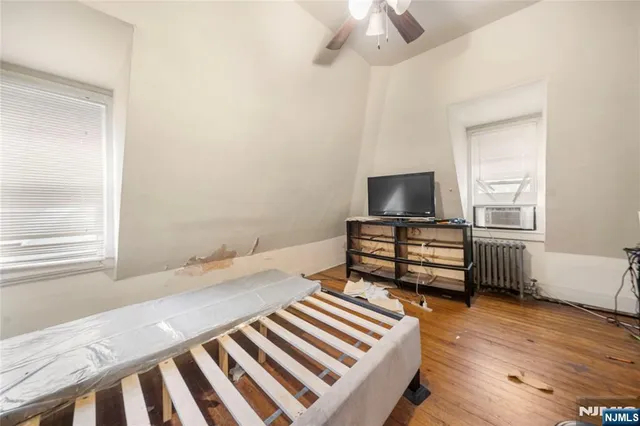 a bedroom with a bed and a tv on the wall