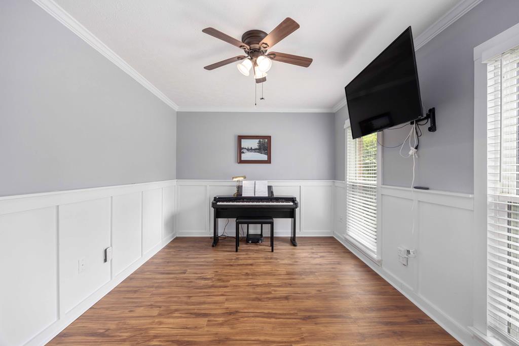 520 Terry Lane Fortson, GA 31808 - Photo 18 of 52 a view of a livingroom with a flat screen tv wooden floor and a ceiling fan
