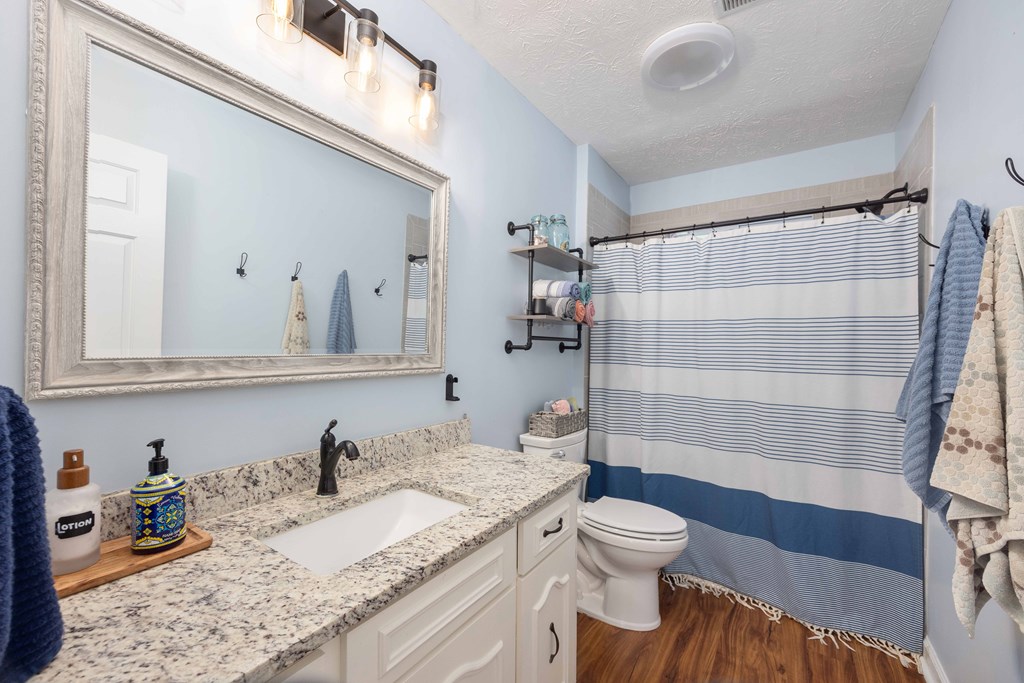 520 Terry Lane Fortson, GA 31808 - Photo 23 of 52 a bathroom with a granite countertop sink toilet mirror and shower