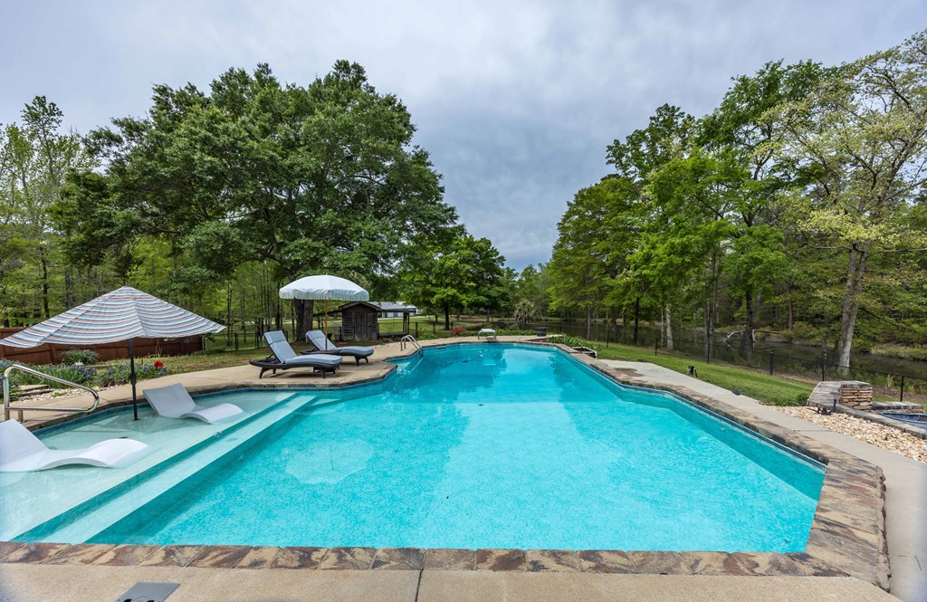 520 Terry Lane Fortson, GA 31808 - Photo 30 of 52 a view of a swimming pool with a lounge chair and a small yard