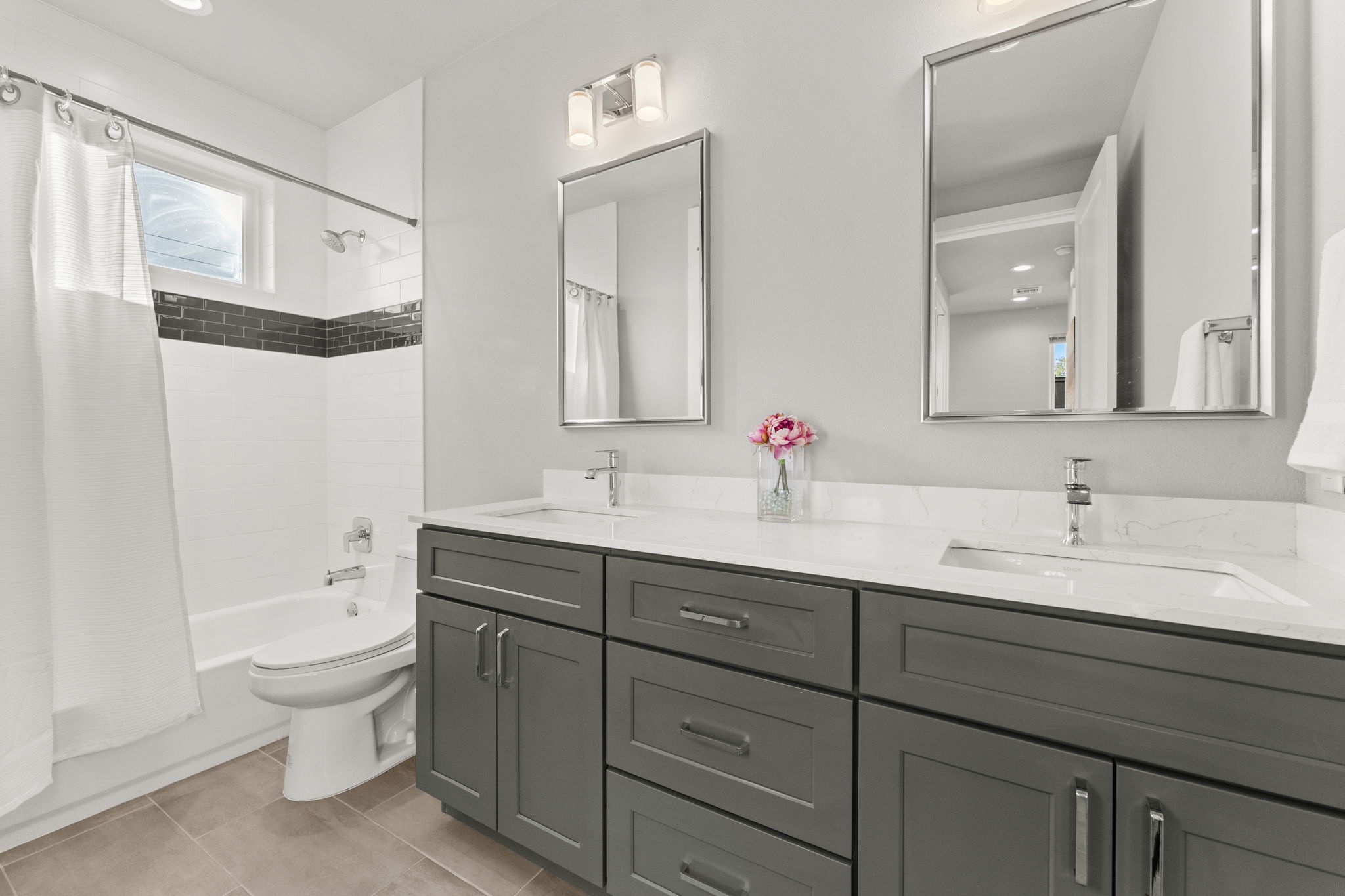 1116 Stobaugh Street, Unit A Austin, TX 78757 - Photo 24 of 37 a bathroom with a double vanity sink toilet mirror and bathtub