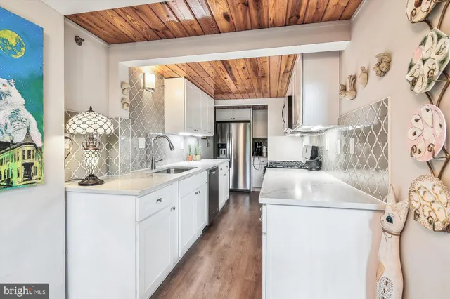 a kitchen with stainless steel appliances a sink stove and cabinets