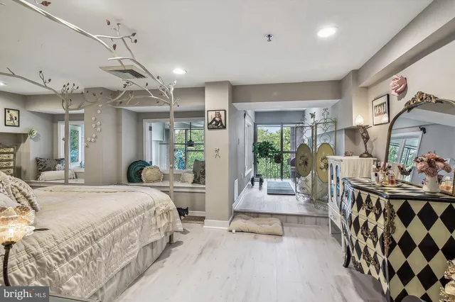 a bedroom with a bed a large window and furniture