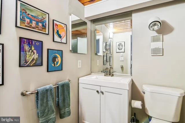a view of staircase with lots of frames on wall and a window