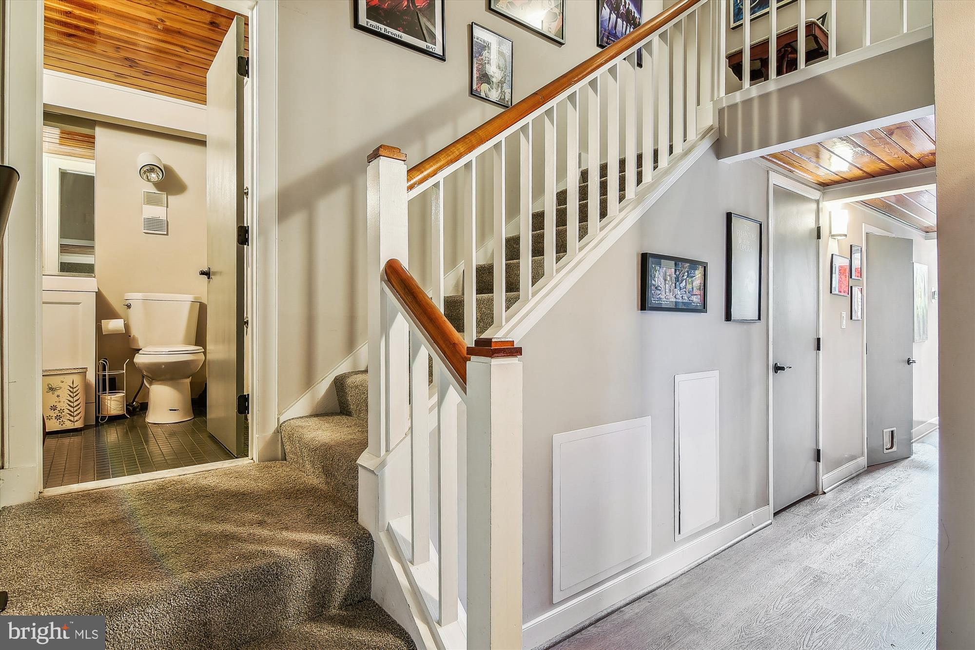 2901 Boston Street, Unit 206 Baltimore, MD 21224 - Photo 43 of 65 a view of staircase with lots of frames on wall and a dining table