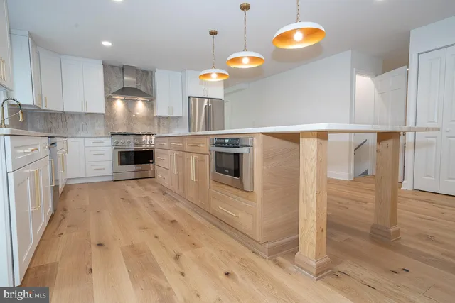 a kitchen with granite countertop a stove a sink and a refrigerator