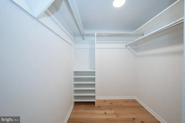 a view of walk in closet with empty racks