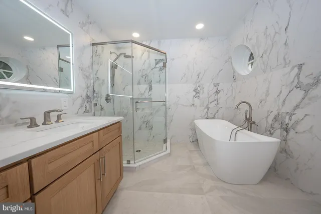 a spacious bathroom with a bathtub sink and mirror