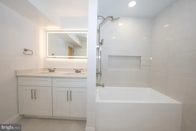 a bathroom with a granite countertop sink a mirror and a bathtub