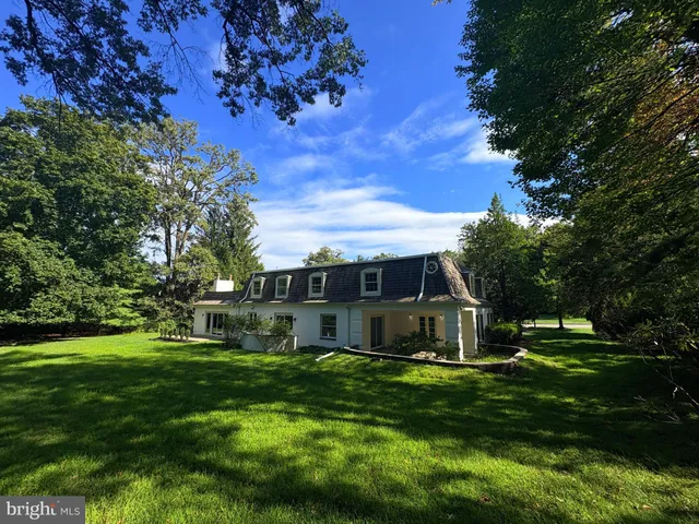a view of a house with a big yard and large trees