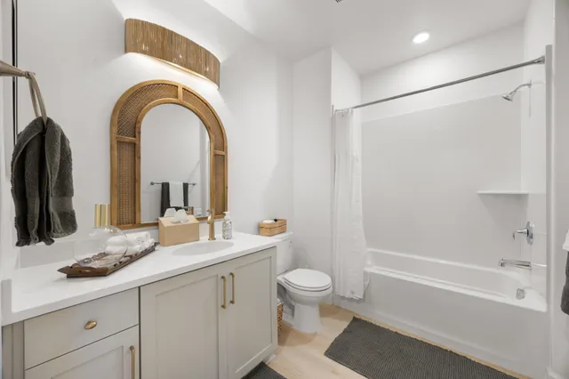 a bathroom with a granite countertop sink a toilet and a bathtub