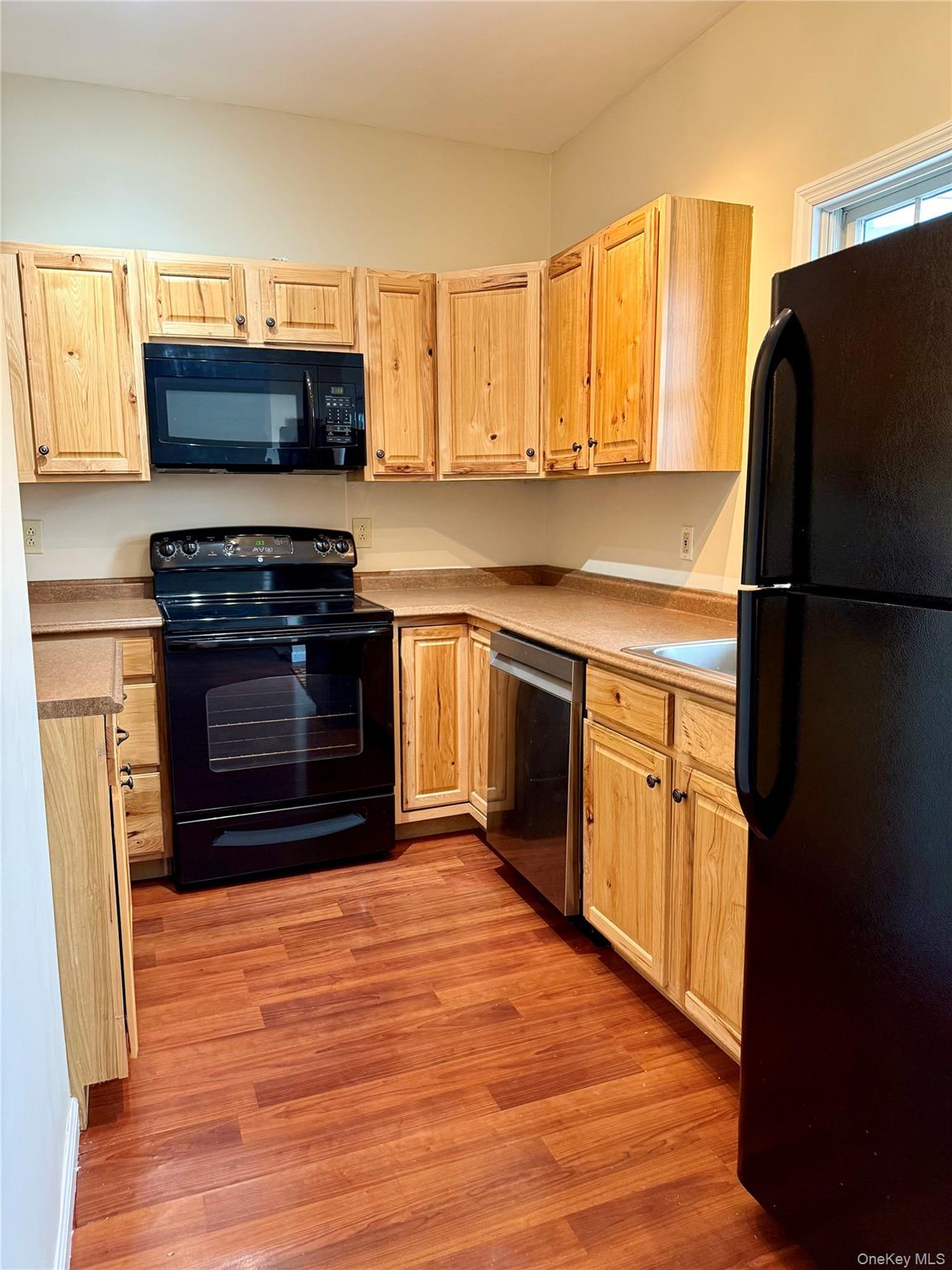 91-97 Sawmill Road Red Hook, NY 12571 - Photo 2 of 8 Kitchen featuring black appliances, light brown cabinetry, light wood-style flooring, and light countertops