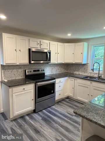 a kitchen with granite countertop a stove and a sink