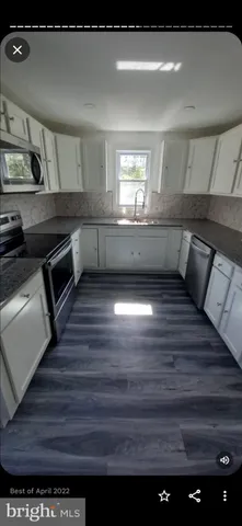 a kitchen with kitchen island a stove and a window