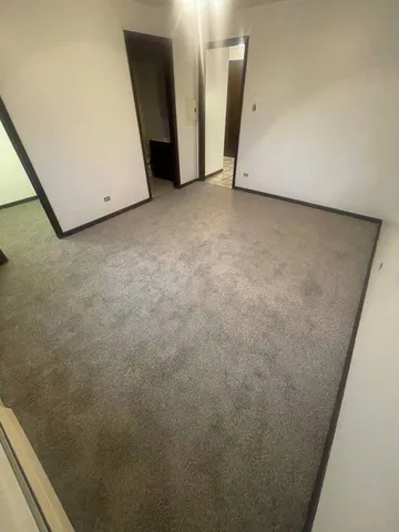 a view of closet area with refrigerator