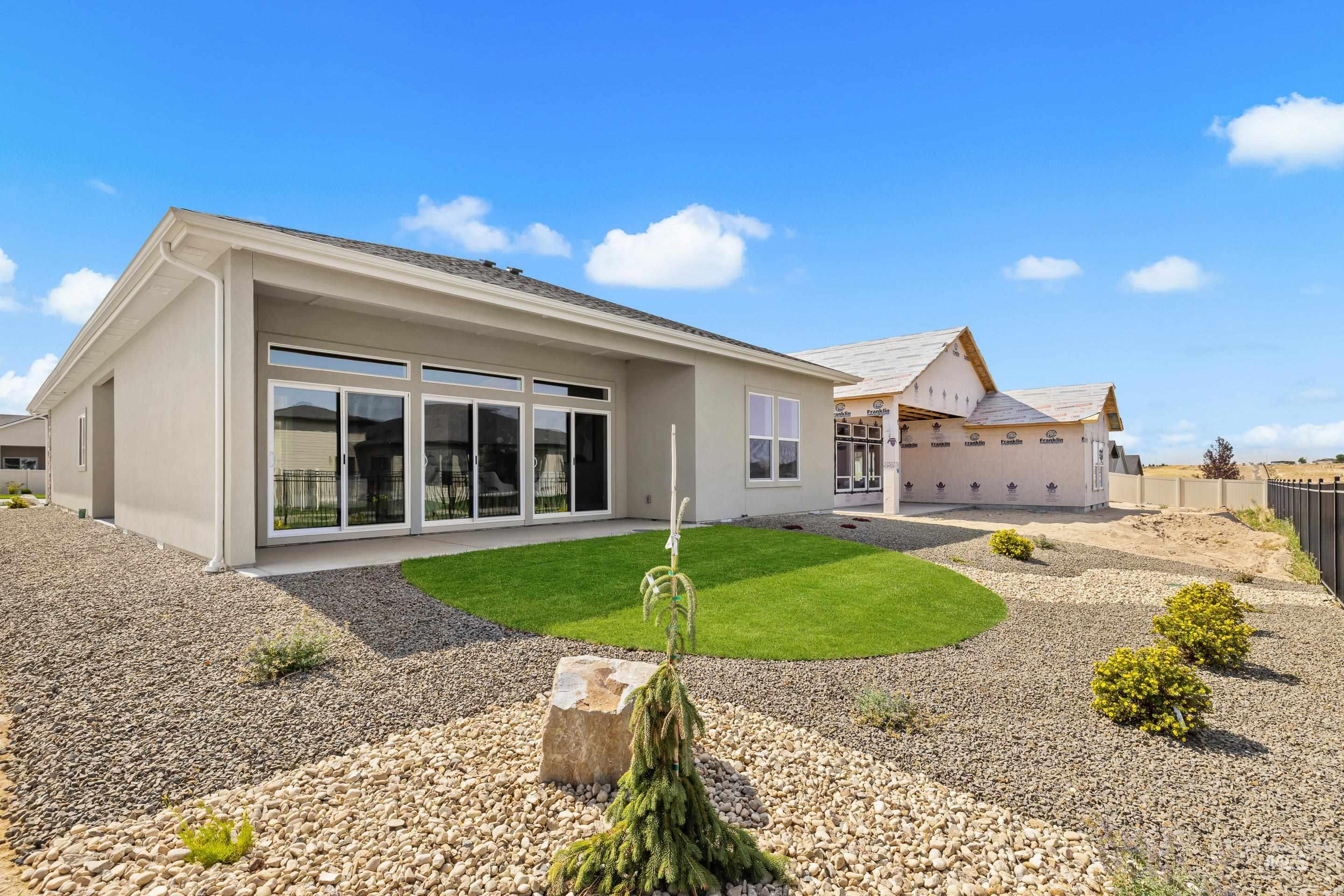 470 South Radiator Way Boise, ID 83716 - Photo 50 of 50 Patio access with sliding glass doors, stucco exterior, covered patio, manicured lawn, and low-maintenance gravel landscaping