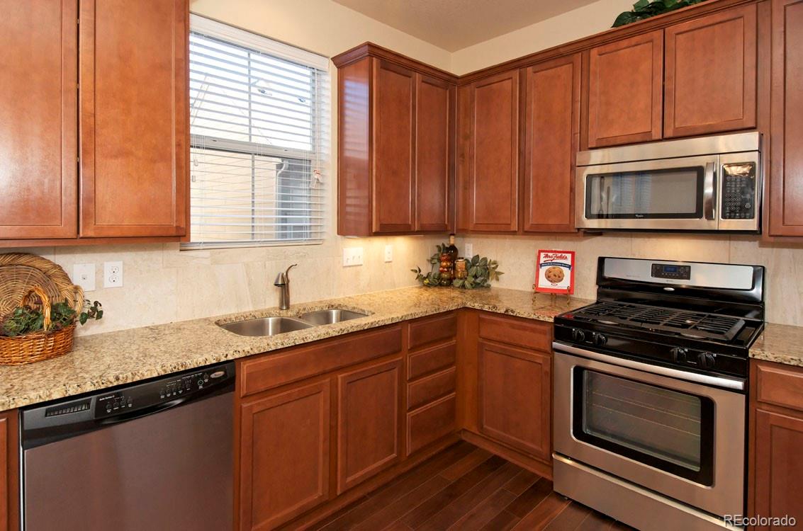 10296 Bellwether Lane Lone Tree, CO 80124 - Photo 12 of 29 a kitchen with granite countertop wooden cabinets and a stove top oven
